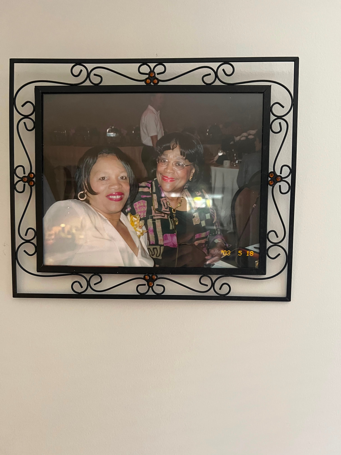 A framed photograph of Debra with an elder family member at a gathering